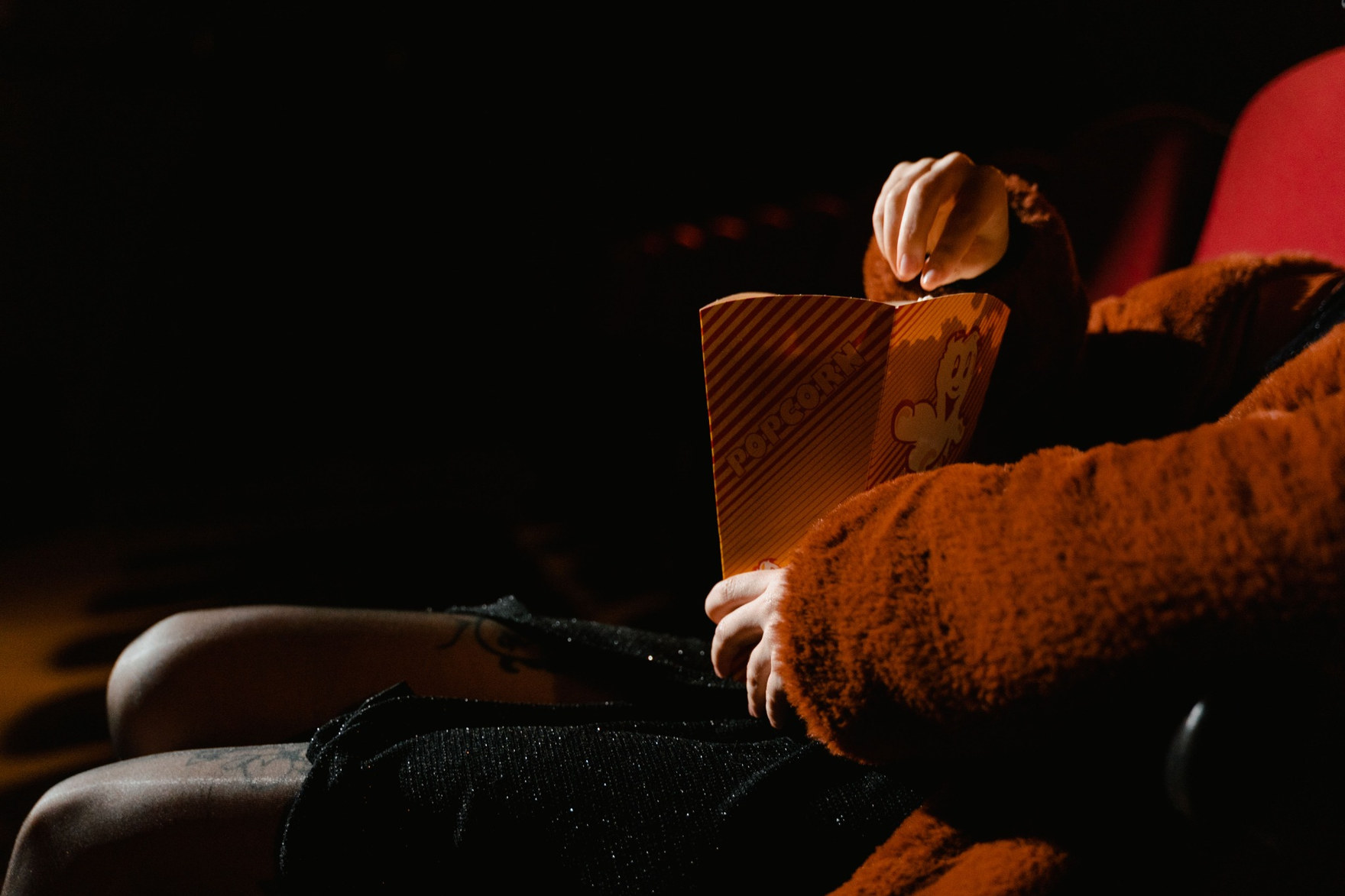Persona con palomitas sentada en una sala de cine